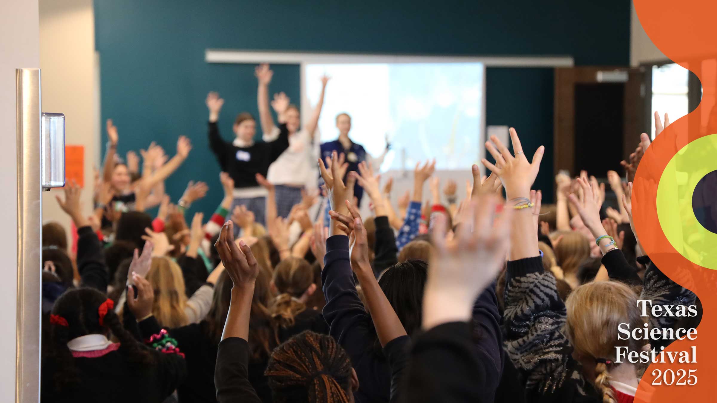 Room full of students with hands raised