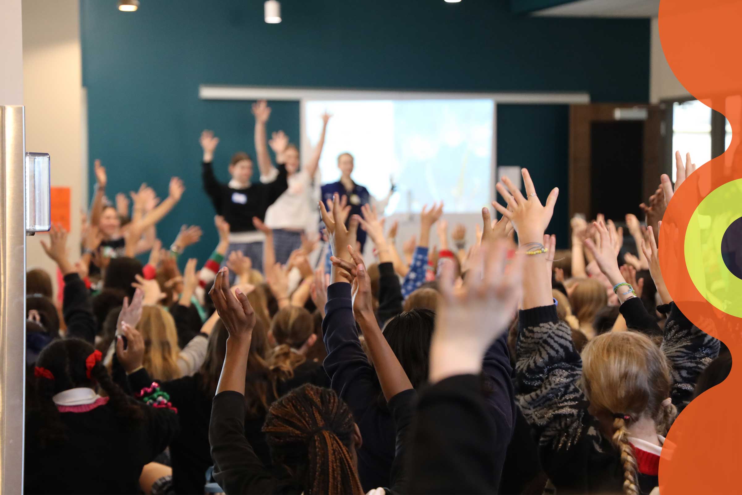 Room full of students with hands raised